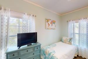 a bedroom with a tv on top of a dresser at Barefoot Cottages #C59 in Highland View