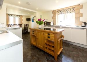 a kitchen with white cabinets and a counter with flowers on it at The Tower in Thorpeness