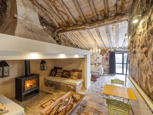 a living room with a fireplace in a stone wall at Belvilla by OYO Cottage Fraga in Torrente de Cinca