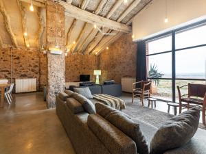 a living room with a large couch and a large window at Belvilla by OYO Cottage Fraga in Torrente de Cinca