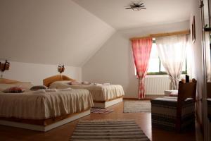 1 dormitorio con 2 camas y ventana en Hanul Kassay, en Frumoasa