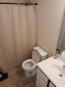 biała łazienka z toaletą i umywalką w obiekcie Large Modern Residence with private guest, family room & business office w mieście Missouri City