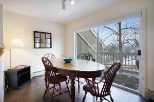 a dining room with a table and chairs and a balcony at Mountainside Resort IV in Stowe