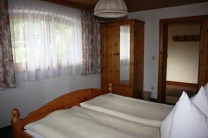 Schlafzimmer mit einem Holzbett und einem Spiegel in der Unterkunft Haus Ampferstein in Telfes im Stubai