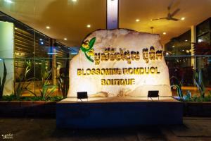 a sign for a restaurant with a large rock at Blossoming Romduol Boutique in Siem Reap