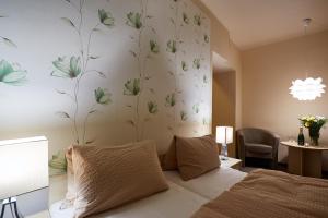 a bedroom with a bed with a flower mural on the wall at Hotel Slunce in Rýmařov