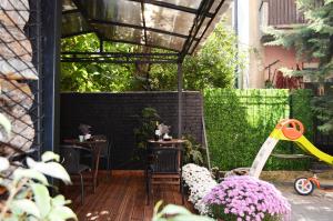 a patio with two tables and chairs and flowers at Ara in Skopje