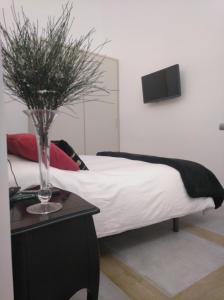 a bedroom with a bed with a vase on a table at Apartamento Urieli in Santander