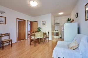 - un salon avec une table et un réfrigérateur dans l'établissement Apartment Ivanka - 200 m from sea, à Trogir