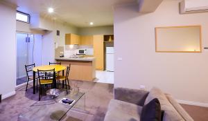 a living room and kitchen with a couch and a table at Flinders Landing Apartments in Melbourne