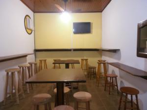 uma sala com mesas e bancos num restaurante em Pousada Praia Vermelha em Penha