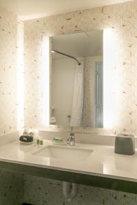 a bathroom with a sink and a mirror at Holiday Inn & Suites Orlando - International Dr S, an IHG Hotel in Orlando