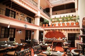 a restaurant with tables and chairs in a building at Hotel Real Catedral in Tula de Allende