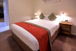 a bedroom with a large bed with two night stands and two lamps at Flinders Landing Apartments in Melbourne