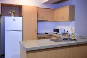 a kitchen with a white refrigerator and a sink at Flinders Landing Apartments in Melbourne