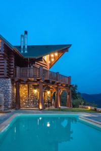 a house with a swimming pool in front of a building at Mythica Chalet in Karpenisi