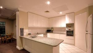 a kitchen with white cabinets and a counter top at Flinders Landing Apartments in Melbourne