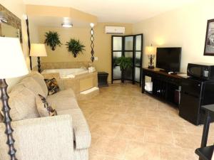 a living room with a couch and a television at Carmel Inn and Suites Thibodaux in Thibodaux