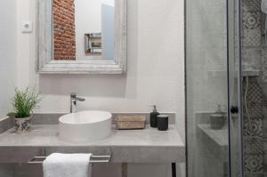 uma casa de banho branca com um lavatório e um espelho em Cosy Apartment in the heart of Barrio de las Letras em Madri
