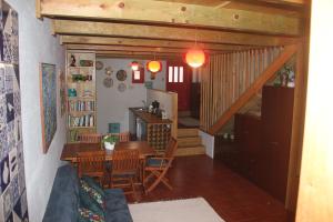 a living room with a table and chairs and a staircase at Casa do Mar in Vila Chã