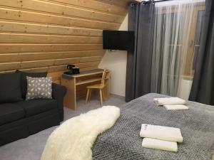 a bedroom with a bed and a couch and a desk at Rezydencja Kojsowka in Witów