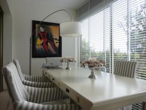 una mesa de comedor con sillas blancas y una pintura en B&B Villa Feline en Cannes