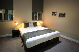 a bedroom with a large bed with two lamps at Flinders Landing Apartments in Melbourne