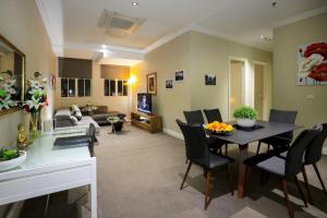 a living room with a table and chairs and a couch at Flinders Landing Apartments in Melbourne