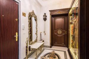 einen Flur mit einer Tür, einer Bank und einem Spiegel in der Unterkunft USSR Apartment in Bukarest