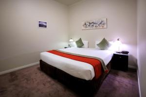 a bedroom with a large white bed in a room at Flinders Landing Apartments in Melbourne