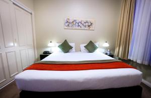 a bedroom with a large white bed with two pillows at Flinders Landing Apartments in Melbourne