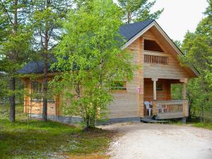 Cabaña de madera con porche y banco en la parte delantera en Ounasloma Luxury Cottages, en Enontekiö