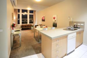 a kitchen and living room with a sink and a counter at Flinders Landing Apartments in Melbourne