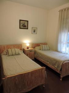 a bedroom with two beds and a lamp on a table at Bosquecito Del Rio in Agua de Oro