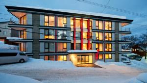 a large building with snow in front of it at Akazora in Niseko