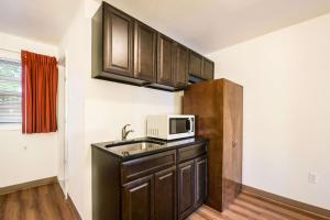 a small kitchen with a sink and a microwave at Motel 6-Tinton Falls, NJ in Tinton Falls