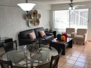 un soggiorno con divano e tavolo in vetro di Espaciosa Suite Zona Centro Col El Prado S7 a Casa Blanca La Corregidora