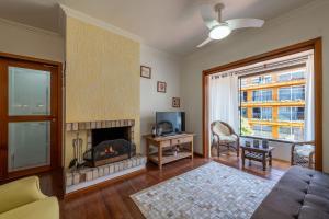 sala de estar con chimenea y TV en Aconchegante Apartamento no Centro de Gramado, en Gramado