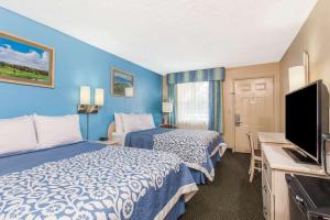 a hotel room with two beds and a flat screen tv at Days Inn by Wyndham Bradenton I-75 in Bradenton