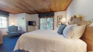 
a bedroom with a bed, a chair, and a window at Christiania Lodge, a Destination by Hyatt Hotel in Vail
