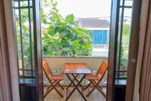 a table and chairs on a balcony with a view at Maison Hai Homestay Hoi An in Hoi An