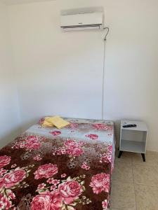1 dormitorio con 1 cama con edredón de flores en Ap beira da Praia das Ondinas, en São Lourenço do Sul