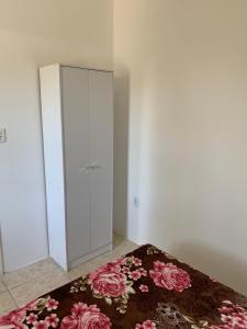 um quarto com uma cama e um armário com um tapete em Ap beira da Praia das Ondinas em São Lourenço do Sul