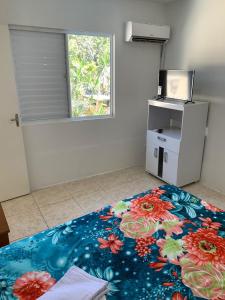 a room with a bed with a flower carpet at Apartamento beira da Praia das Ondinas in São Lourenço do Sul