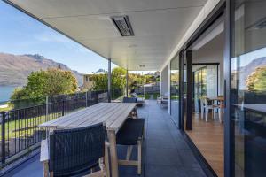 an outdoor patio with a wooden table and chairs at Waipatiki by Sotheby's Luxury Rental Homes in Queenstown +5 photos