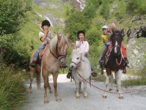 tres niños montando a caballo en un sendero en Gappmayrhof en Tamsweg