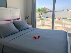 a bed with flowers on it with a view of a patio at Genesis Apartments in Palm-Eagle Beach
