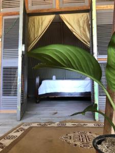 um quarto com uma cama com uma planta em Surfhost em Garza