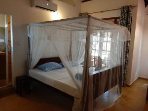 un letto a baldacchino in una stanza di Sea Breeze Guest house a Unawatuna