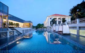 uma piscina com guarda-sóis ao lado de um edifício em Hotel Fort Canning em Singapura